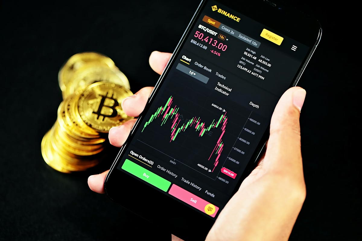 a smartphone displaying bitcoin's price with several bitcoins next to it