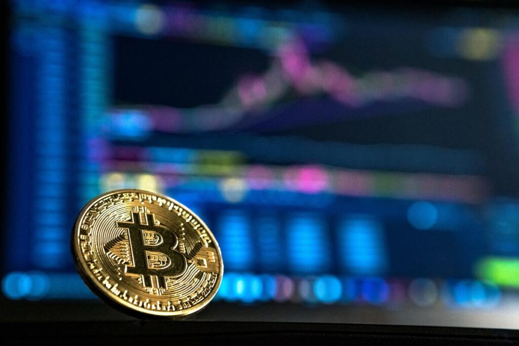 A picture of a bitcoin with an opaque background of a screen showing a chart